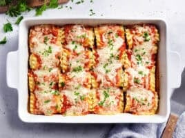 Overhead view of lasagna roll ups in a baking dish.