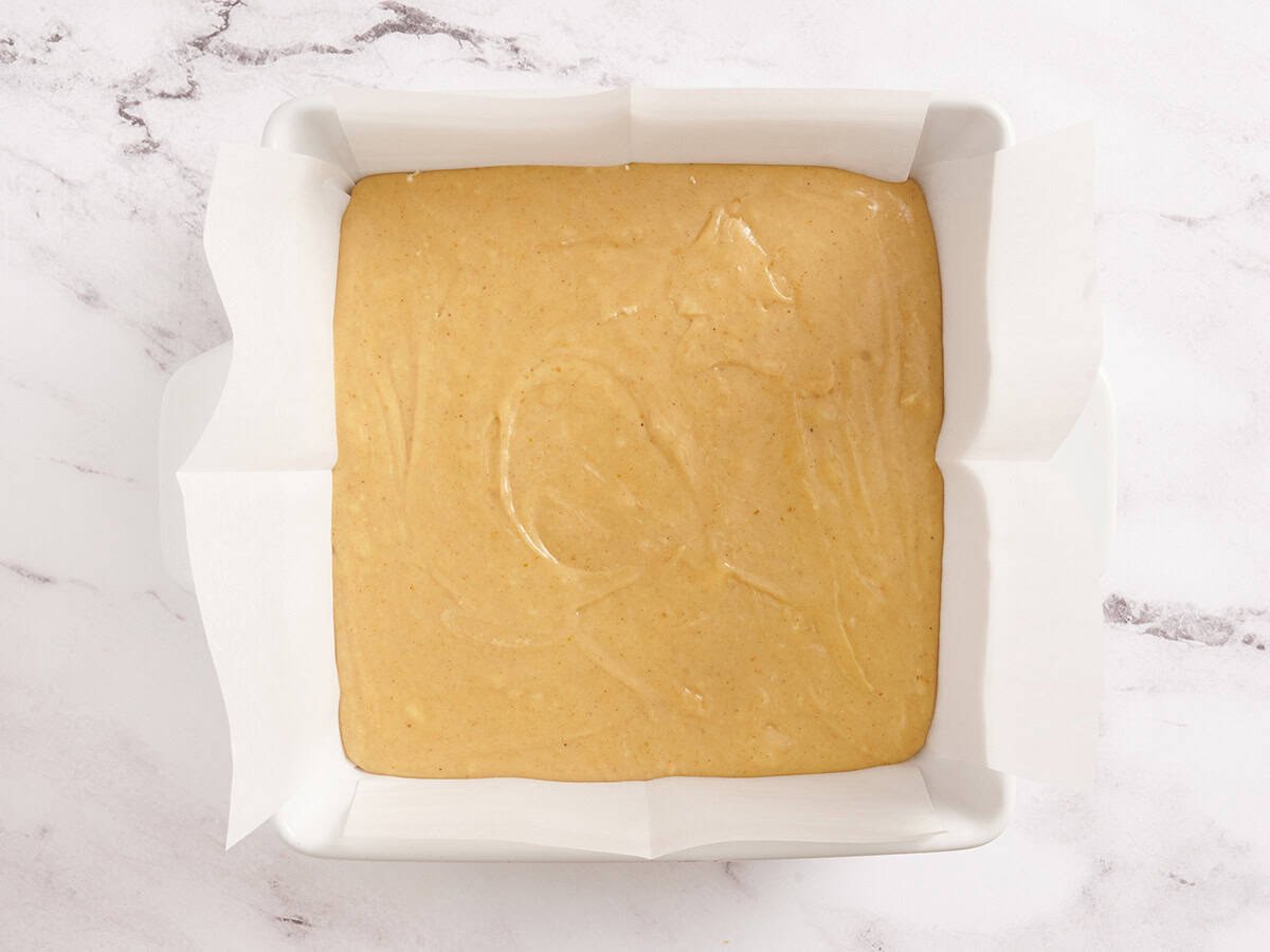 Pumpkin spice fudge in a parchment lined baking dish.