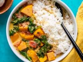 Close up overhead view of butternut squash curry in a bowl with rice.