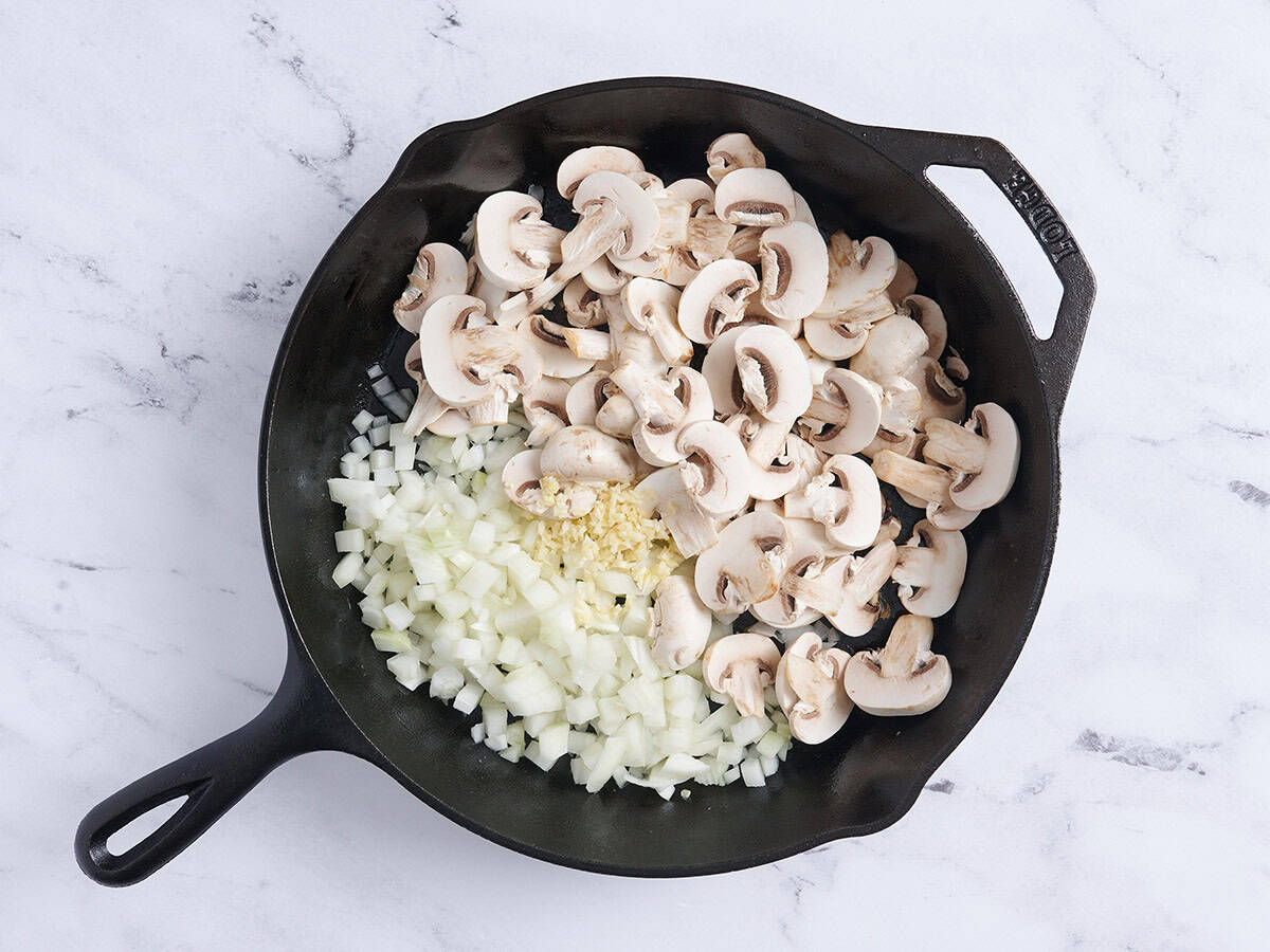 Mushroom, onions and seasoning in a skillet.