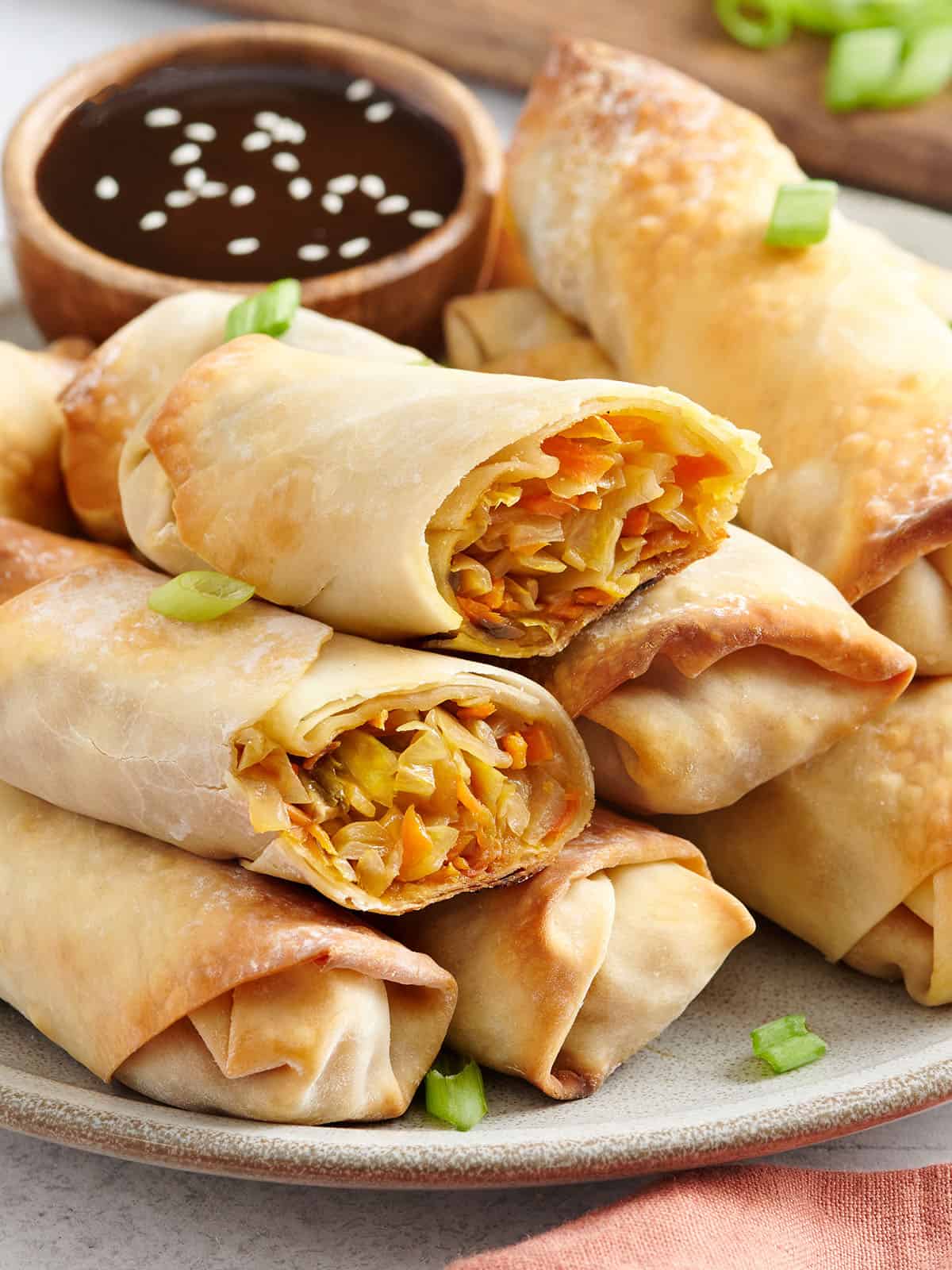 Side view of homemade vegetable egg rolls on a plate.