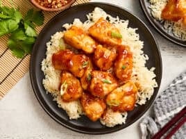 Overhead view of firecracker chicken on a bed of rice.