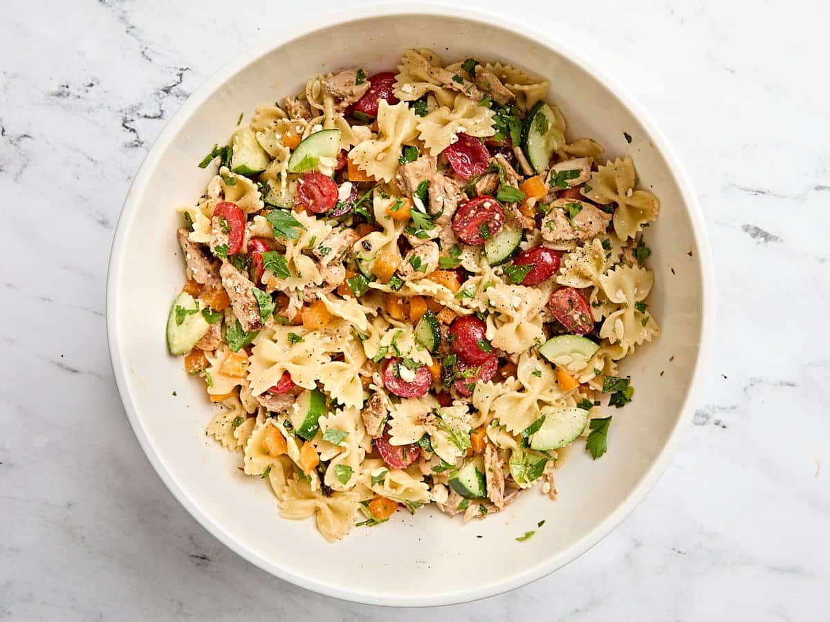 Finished Greek chicken pasta salad in a mixing bowl.
