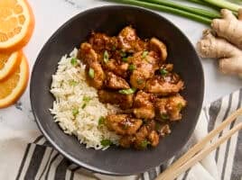 Overhead view of homemade orange chicken in a bowl with rice.