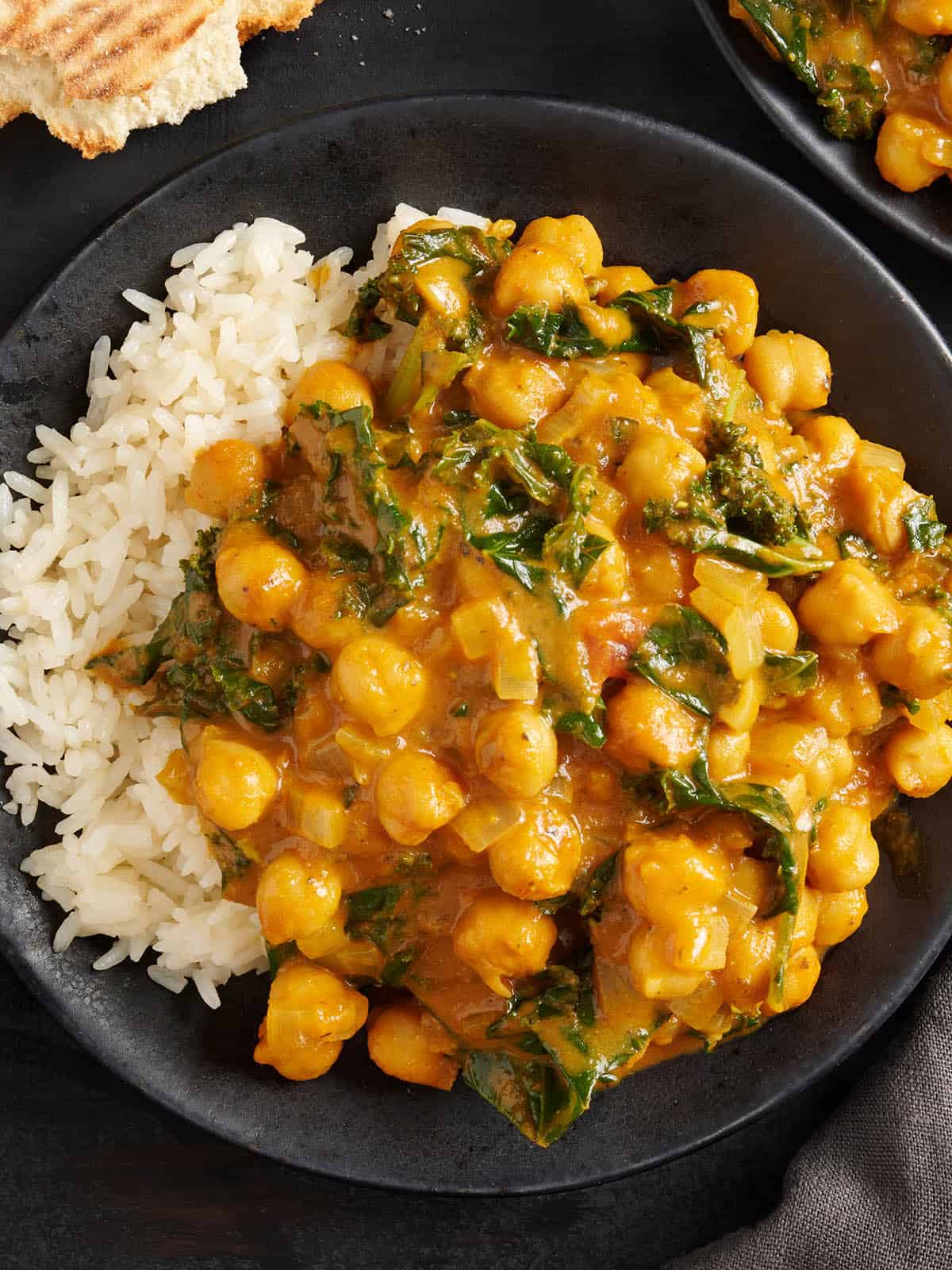 Overhead view of chickpea curry on a plate with white rice.