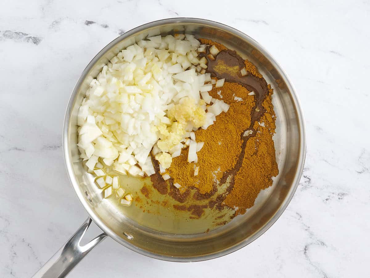 Spices, diced onion, garlic and ginger in a skillet.