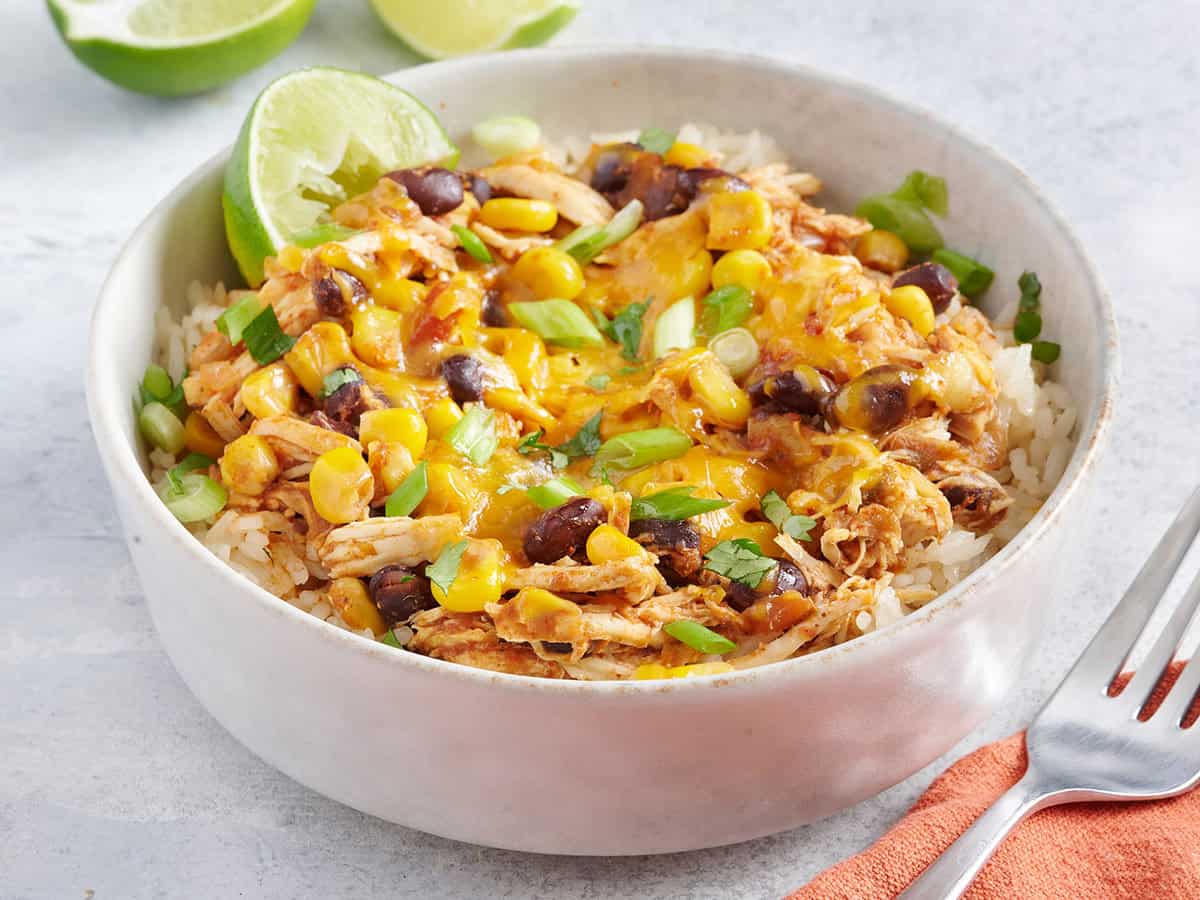 Bowl of white rice with slow cooker chicken tacos.