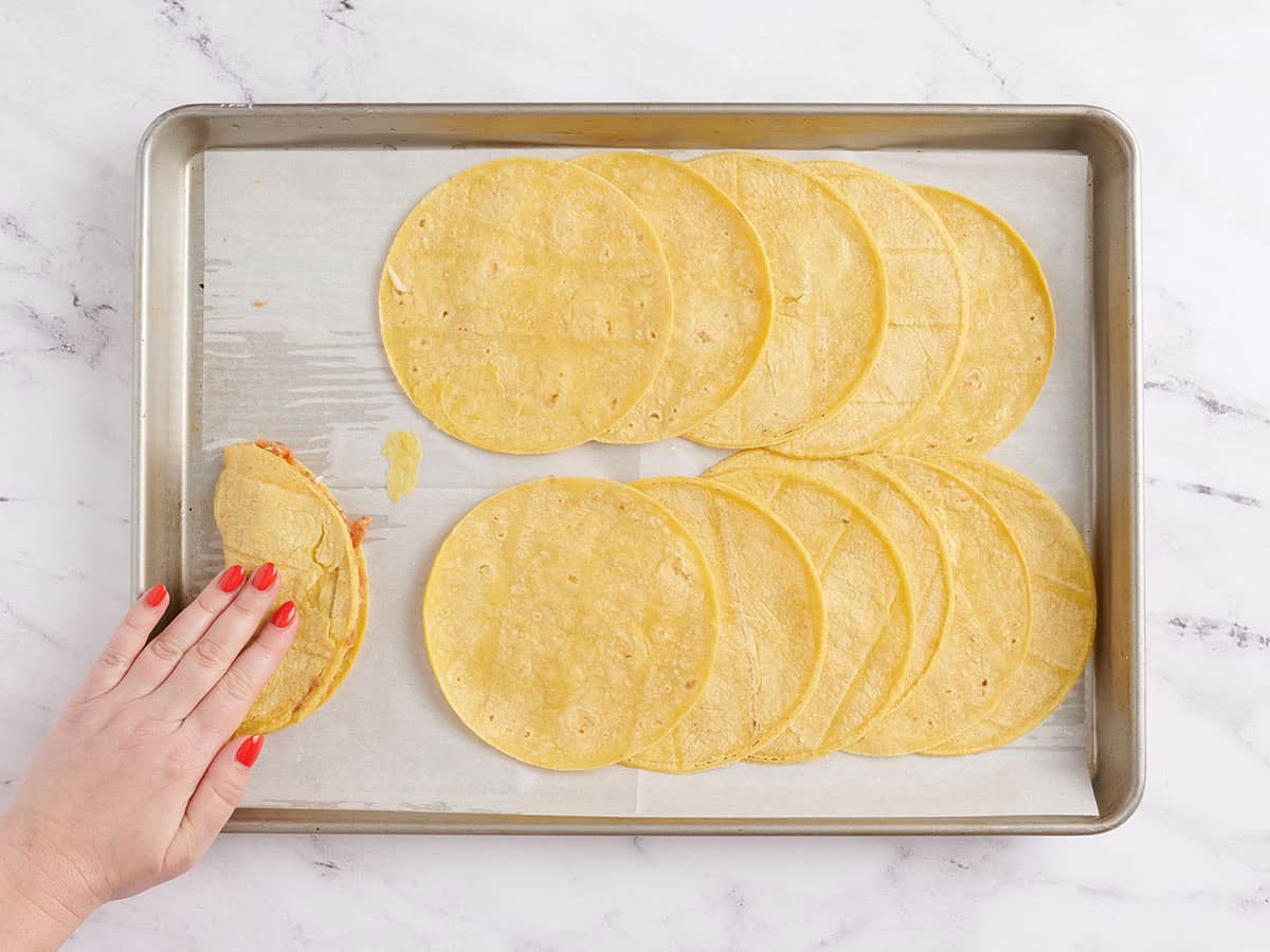 A hand folding over a sheet pan taco.
