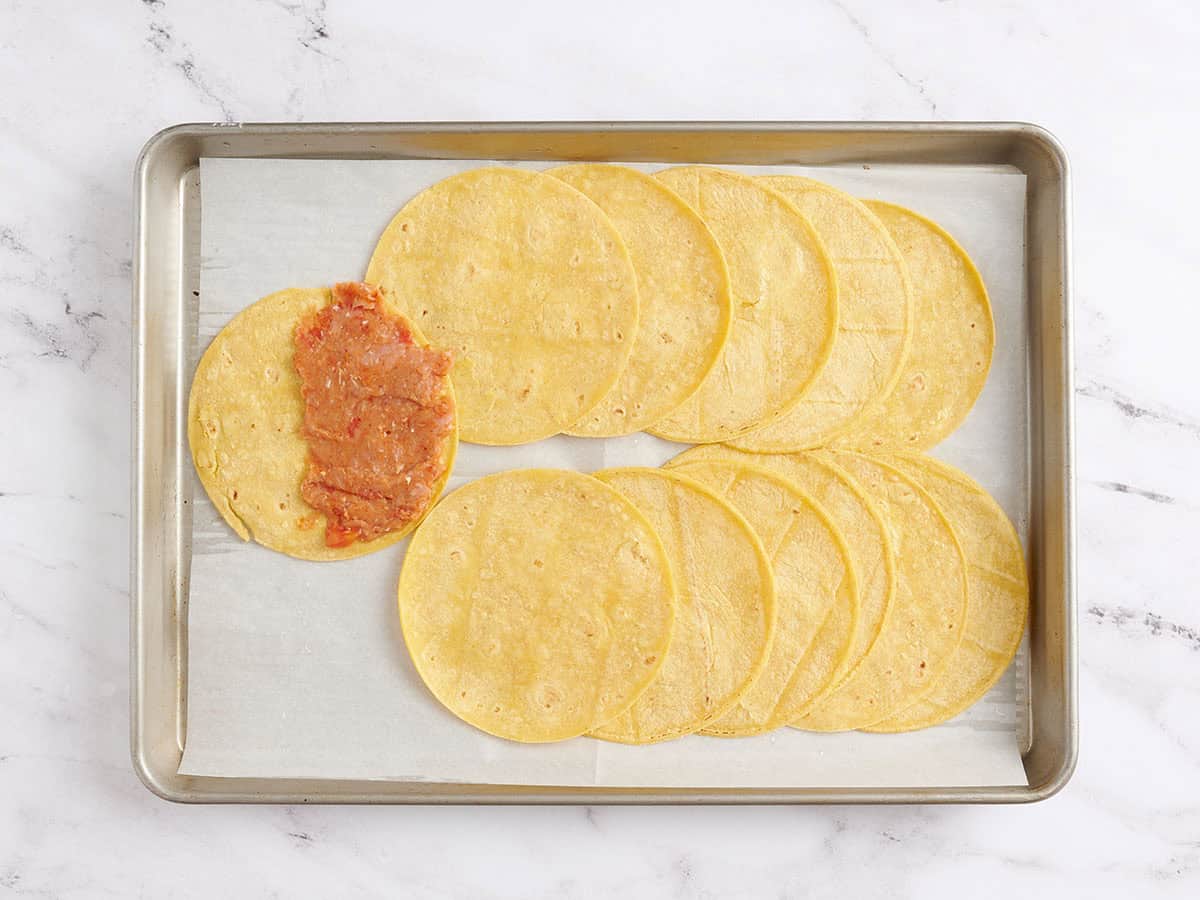 Turkey meat filling spread over one half of a tortilla.