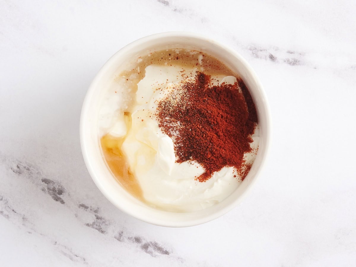 The ingredients to make a sour cream dipping sauce in a bowl.