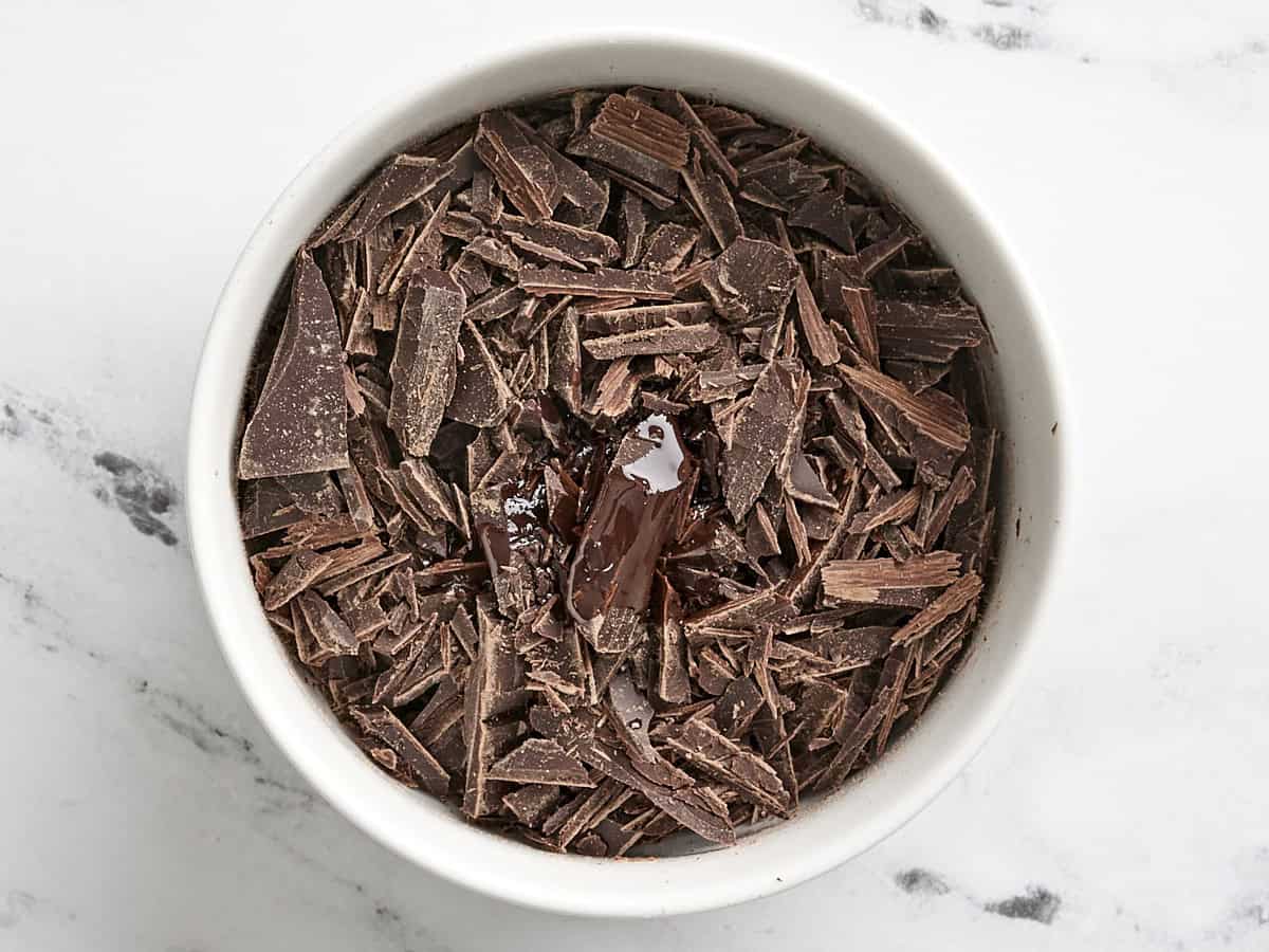 Chopped semi sweet chocolate in a bowl with cooking oil.