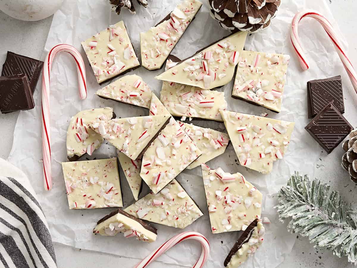 Overhead view of pieces of peppermint bark on parchment paper.