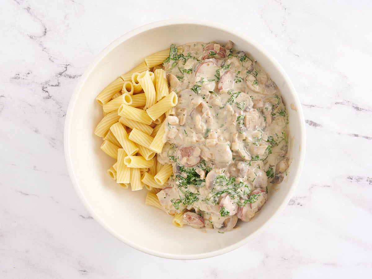 Pasta with a creamy kale sauce in a bowl to make sausage and kale casserole.
