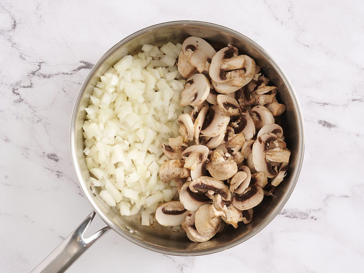 Diced onions and mushrooms in a skillet.