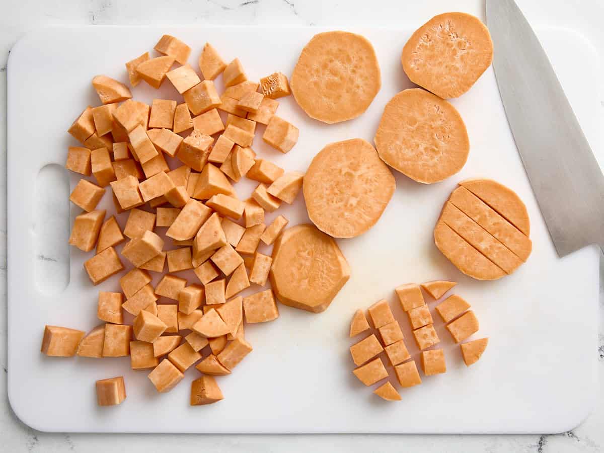 Sweet potatoes cut into cubes on a cutting board.