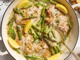 Overhead view of creamy asparagus chicken in a skillet.