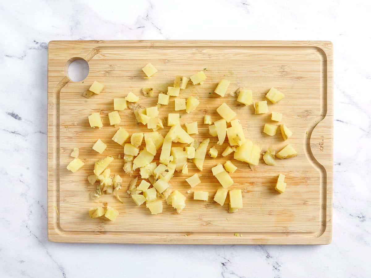 Diced cooked potatoes on a cutting board.