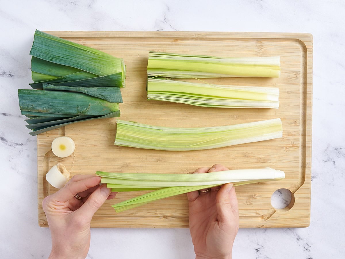 Hands separating leek leaves.