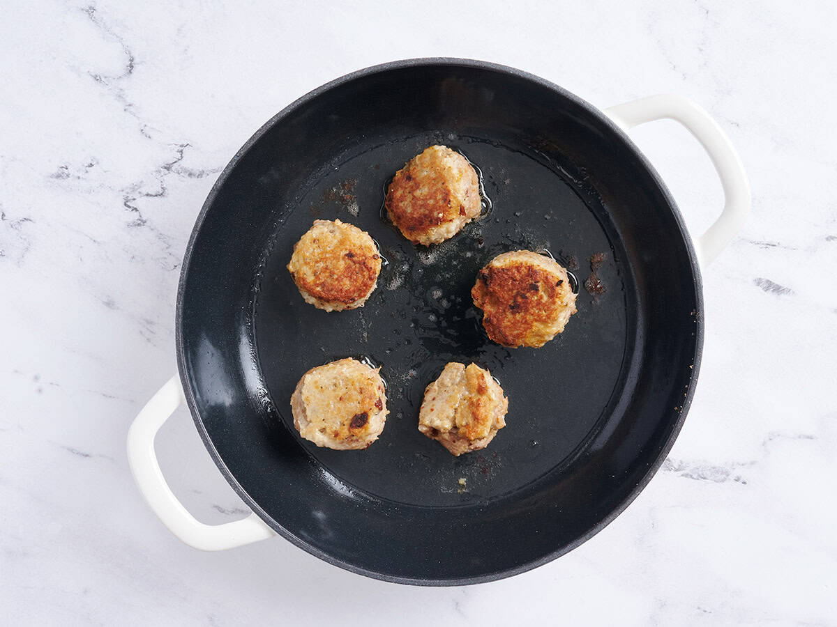 Marry me chicken meatball browning in a skillet.
