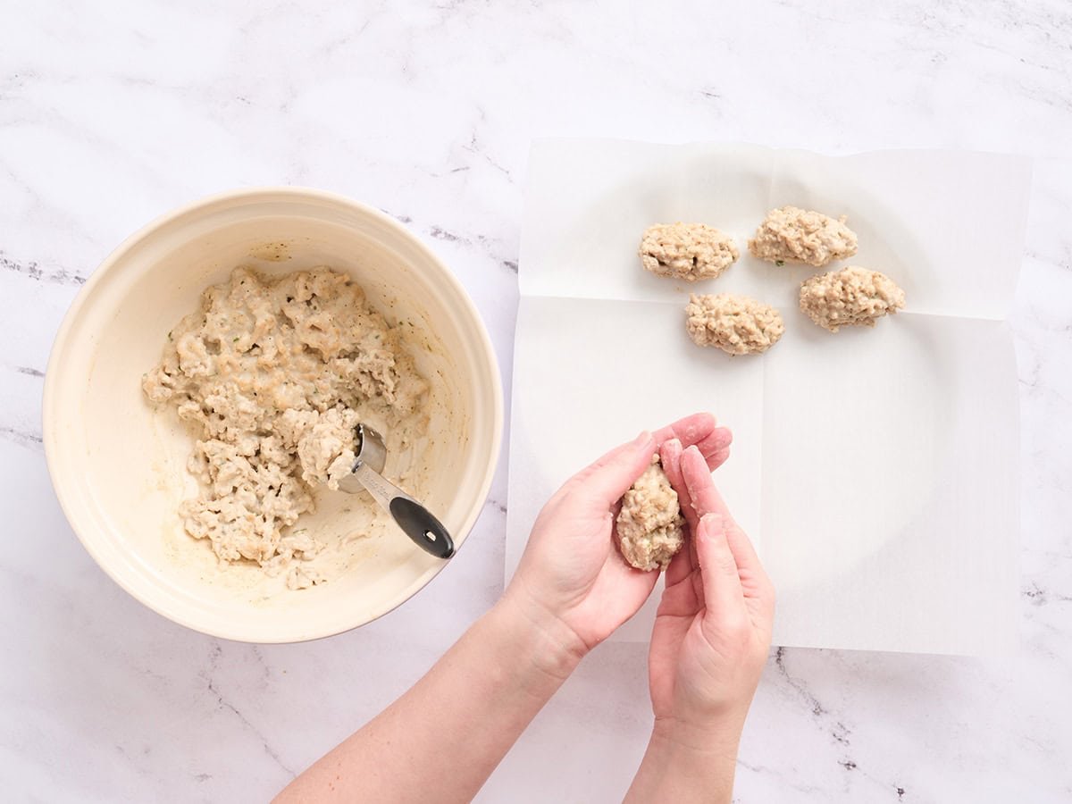 Hands shaping chicken croquettes.