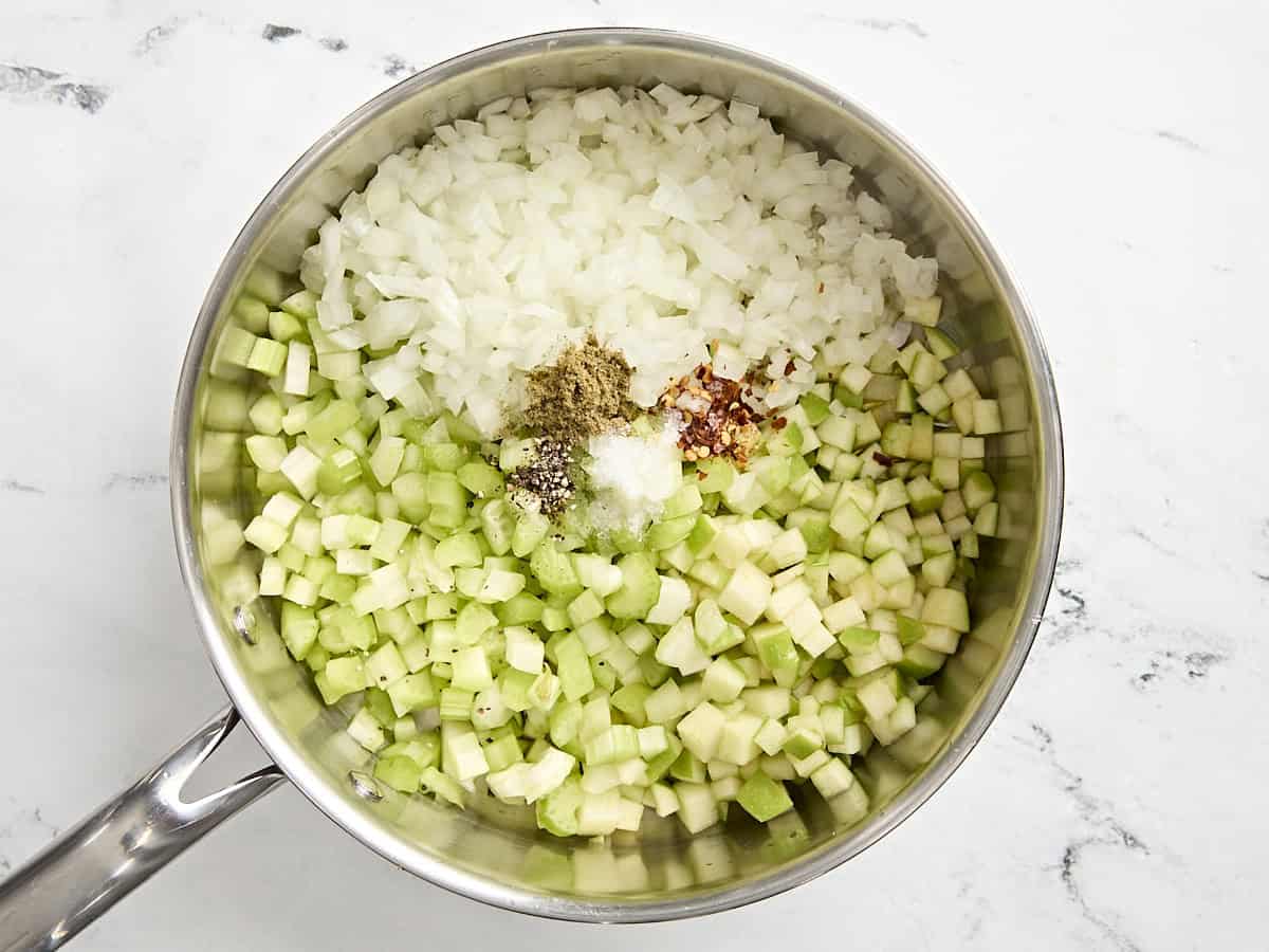 Diced onion and celery in a pan with seasonings.