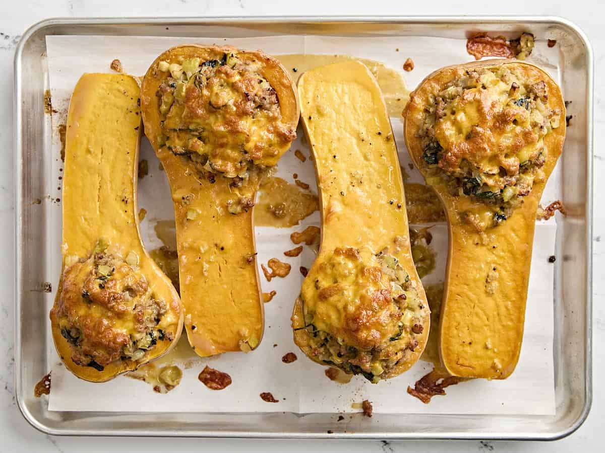 Stuffed butternut squash on a baking sheet.