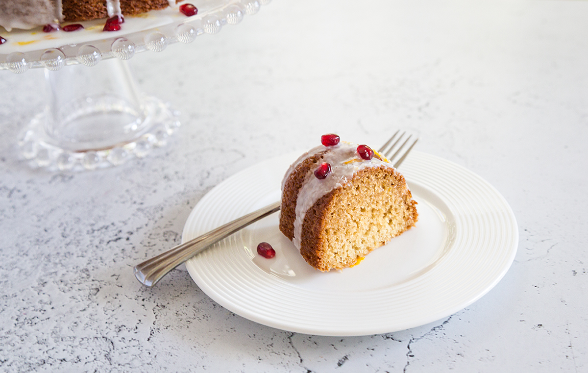 A slice of Oil-Free Vegan Lemon Drizzle Cake with Pomegranate Seeds