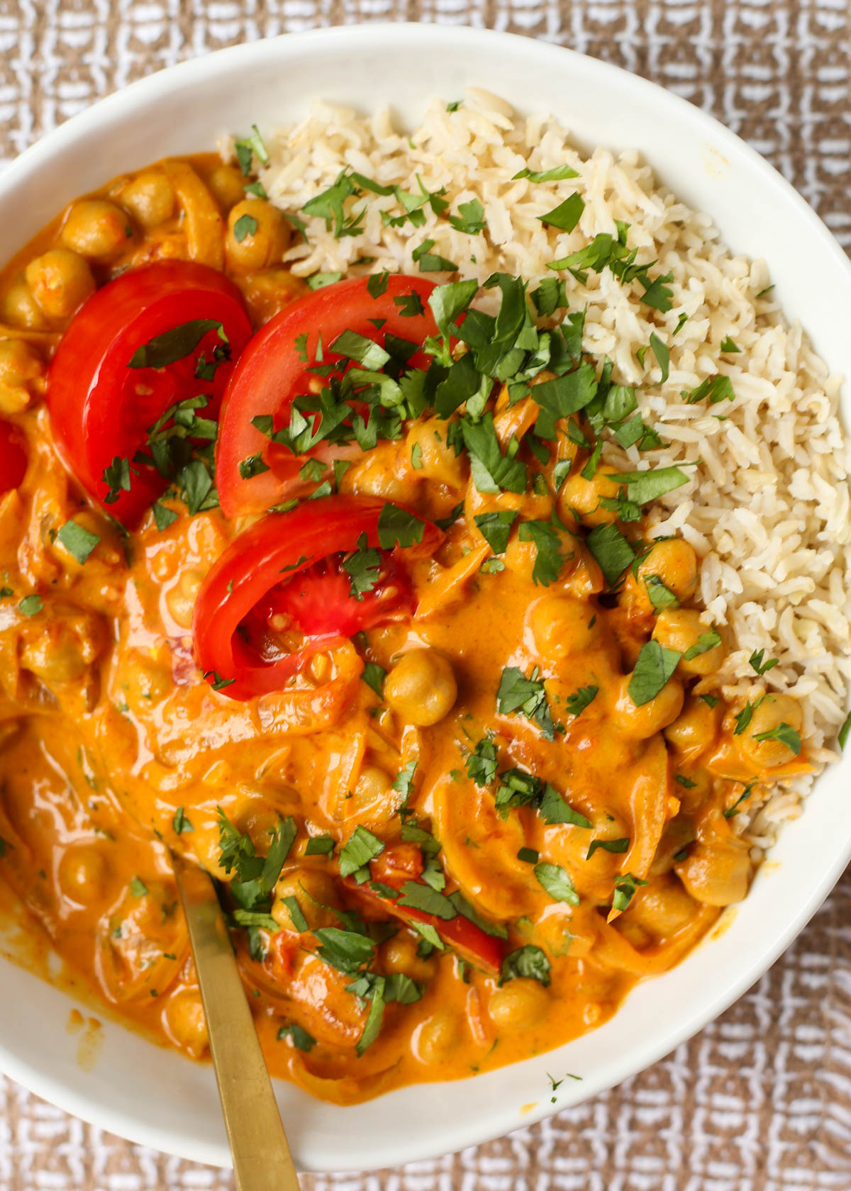 A bowl of tomato and chickpea curry with brown basmati rice
