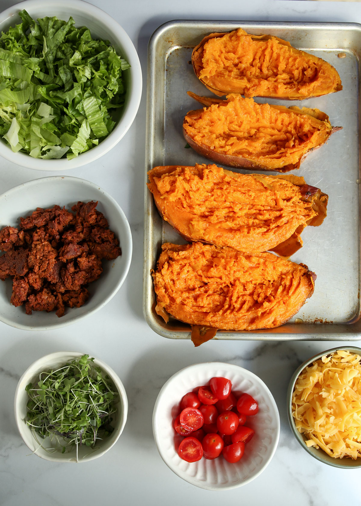 Ingredients for taco-stuffed sweet potatoes on a white background