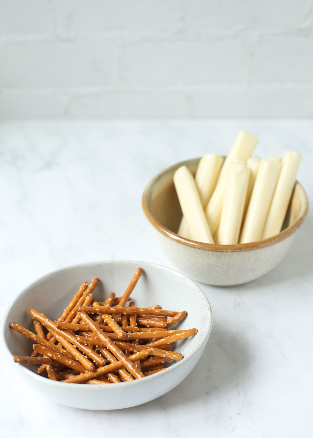 Ingredients for string cheese broomsticks: string cheese and pretzel sticks.