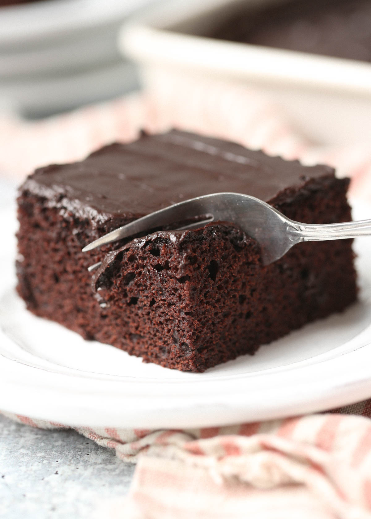 A fork cuts into a square of chocolate wacky cake 